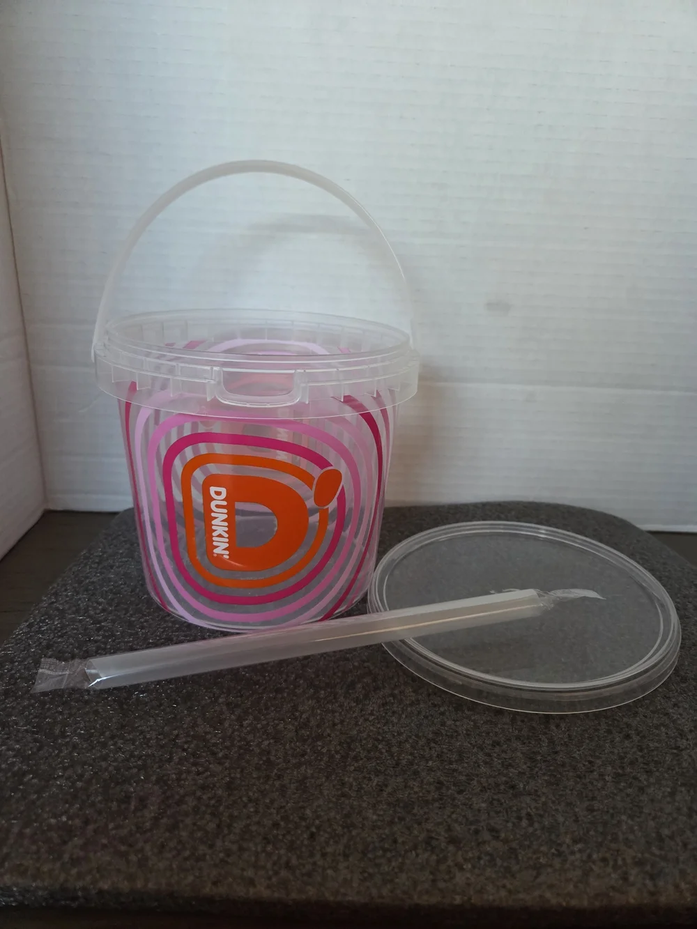 Dunkin' 48 oz. bucket cup with unopened straw.